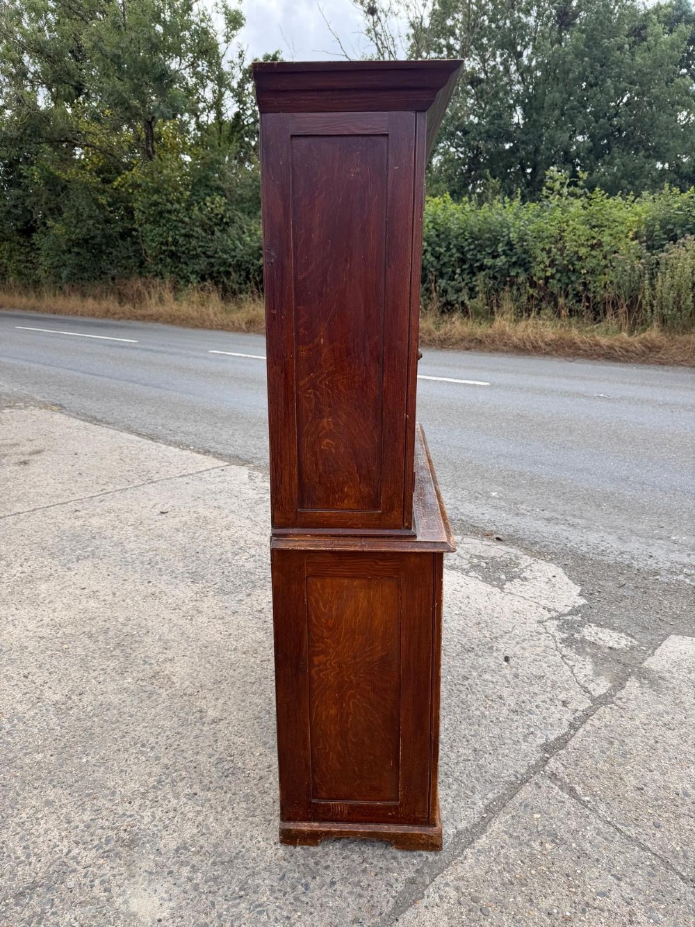 A dark stained Victorian pine dresser featuring a three-door glazed upper display cabinet over a base with three central drawers and two panelled cupboard doors. View VI