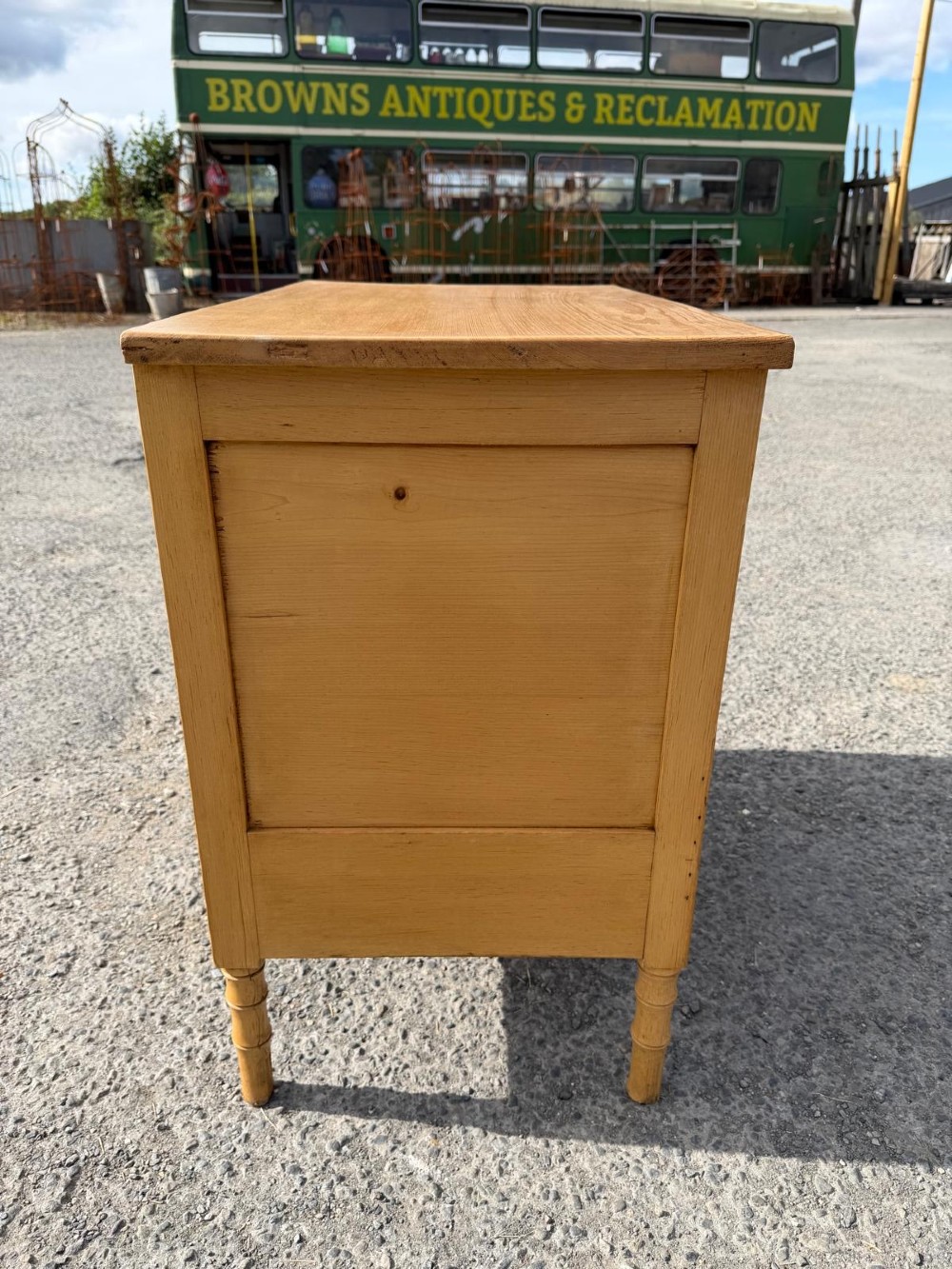 An early 19th-century light pine cupboard featuring double panelled doors, a single lower drawer, and carved faux bamboo frame trim and turned legs. View II