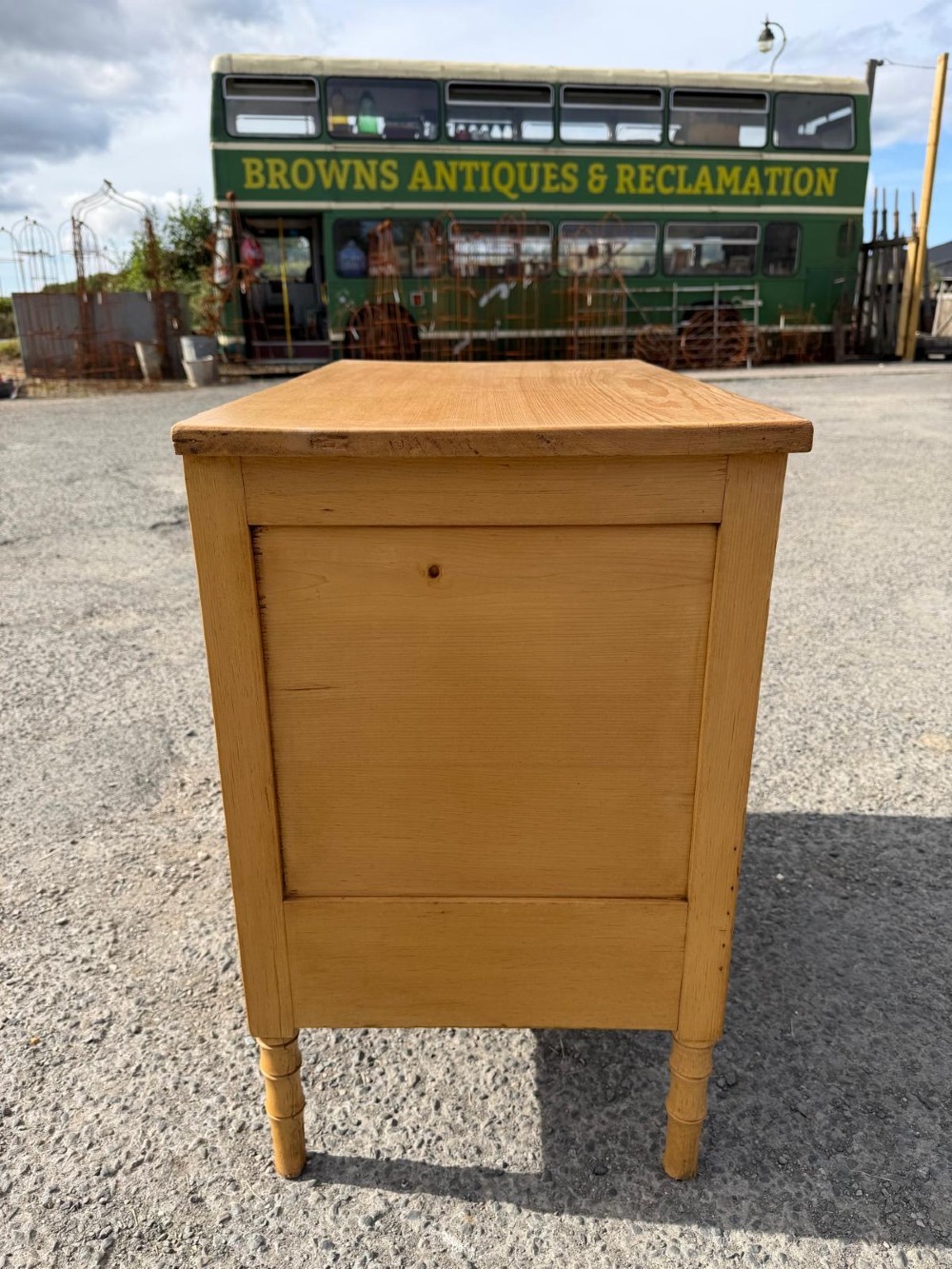 An early 19th-century light pine cupboard featuring double panelled doors, a single lower drawer, and carved faux bamboo frame trim and turned legs. View III