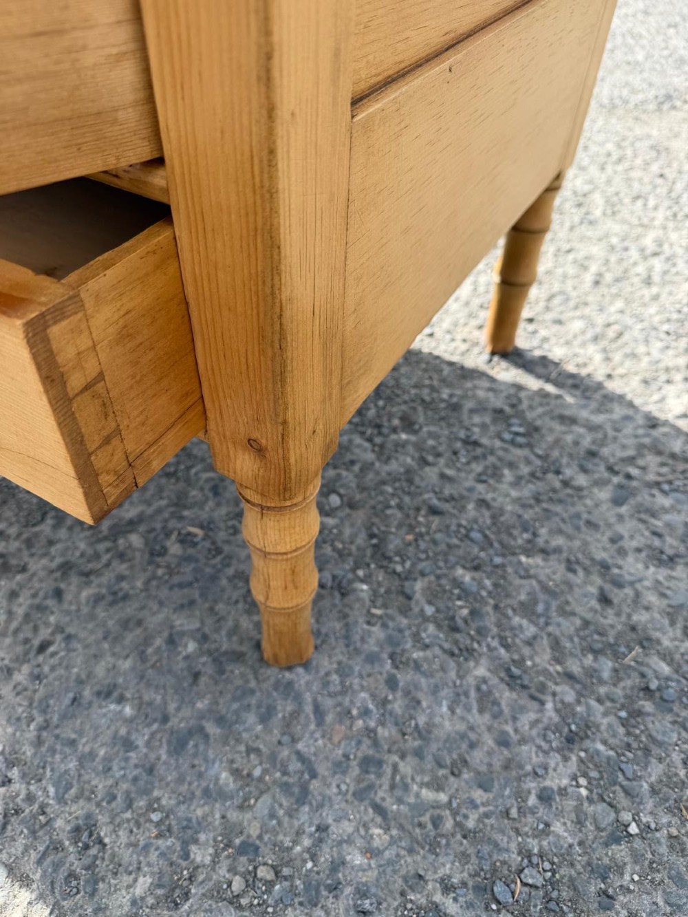 An early 19th-century light pine cupboard featuring double panelled doors, a single lower drawer, and carved faux bamboo frame trim and turned legs. View V