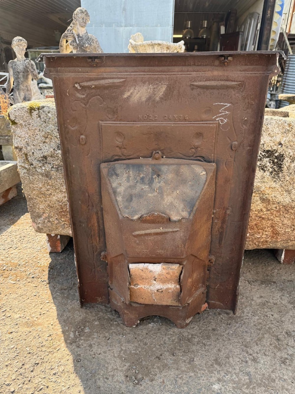 An antique Victorian cast iron combination fireplace featuring relief floral tendrils and seed pod motifs with an integrated grate and mantel shelf. View II