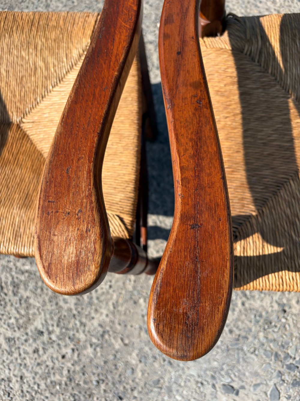 A pair of 19th-century Lancashire ladderback oak carver armchairs featuring curved back slats, turned stretchers, and hand-woven rush seats. View III