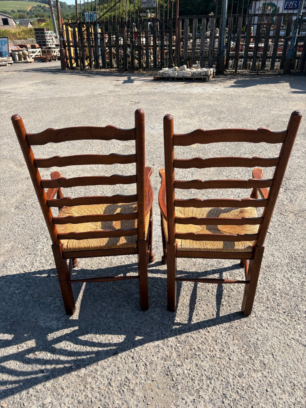 A pair of 19th-century Lancashire ladderback oak carver armchairs featuring curved back slats, turned stretchers, and hand-woven rush seats. View IV