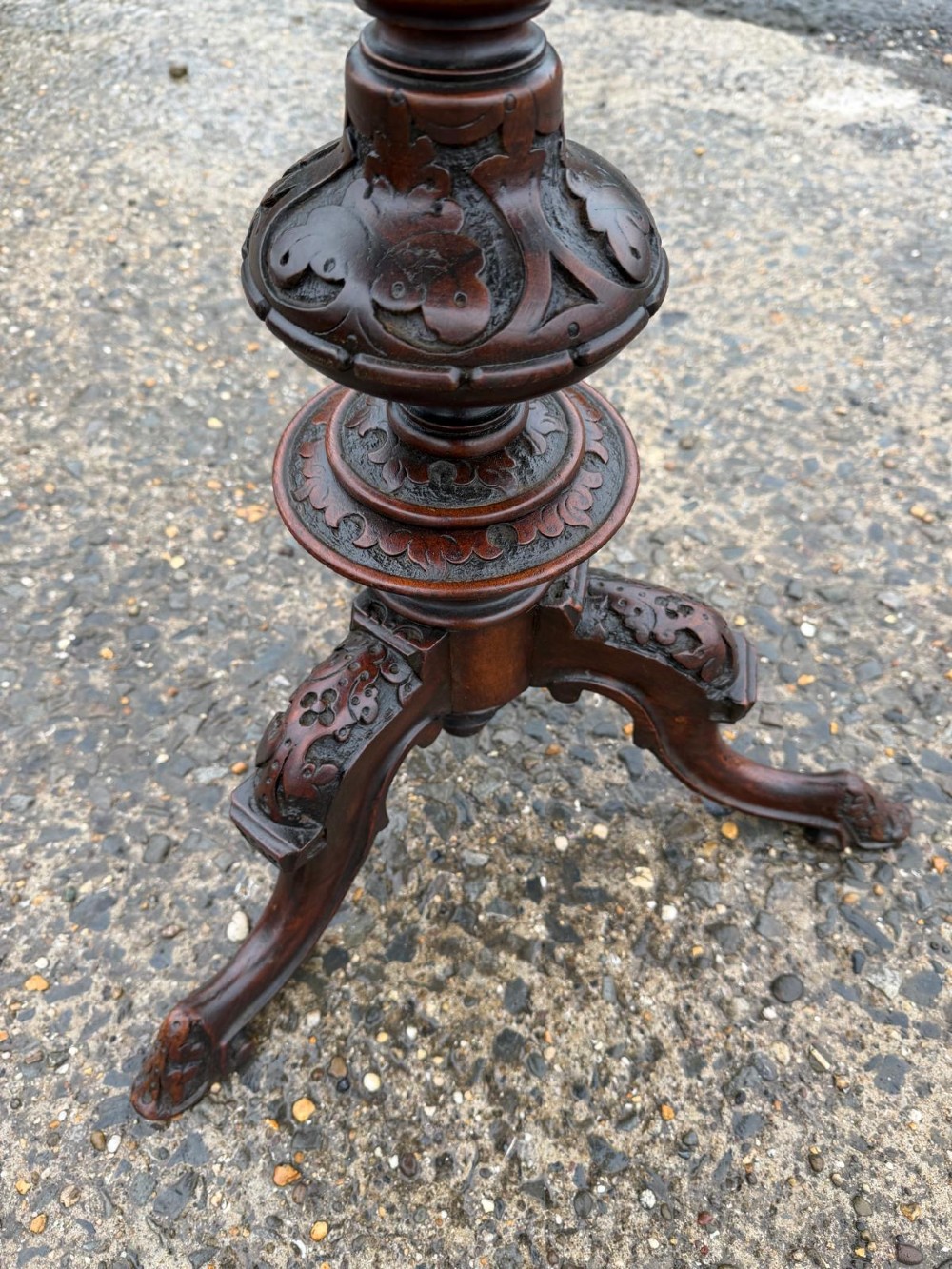 A Victorian mahogany tripod side table with a circular top containing a burr wood inset, a carved border, a turned central support, and three carved splayed legs. View III
