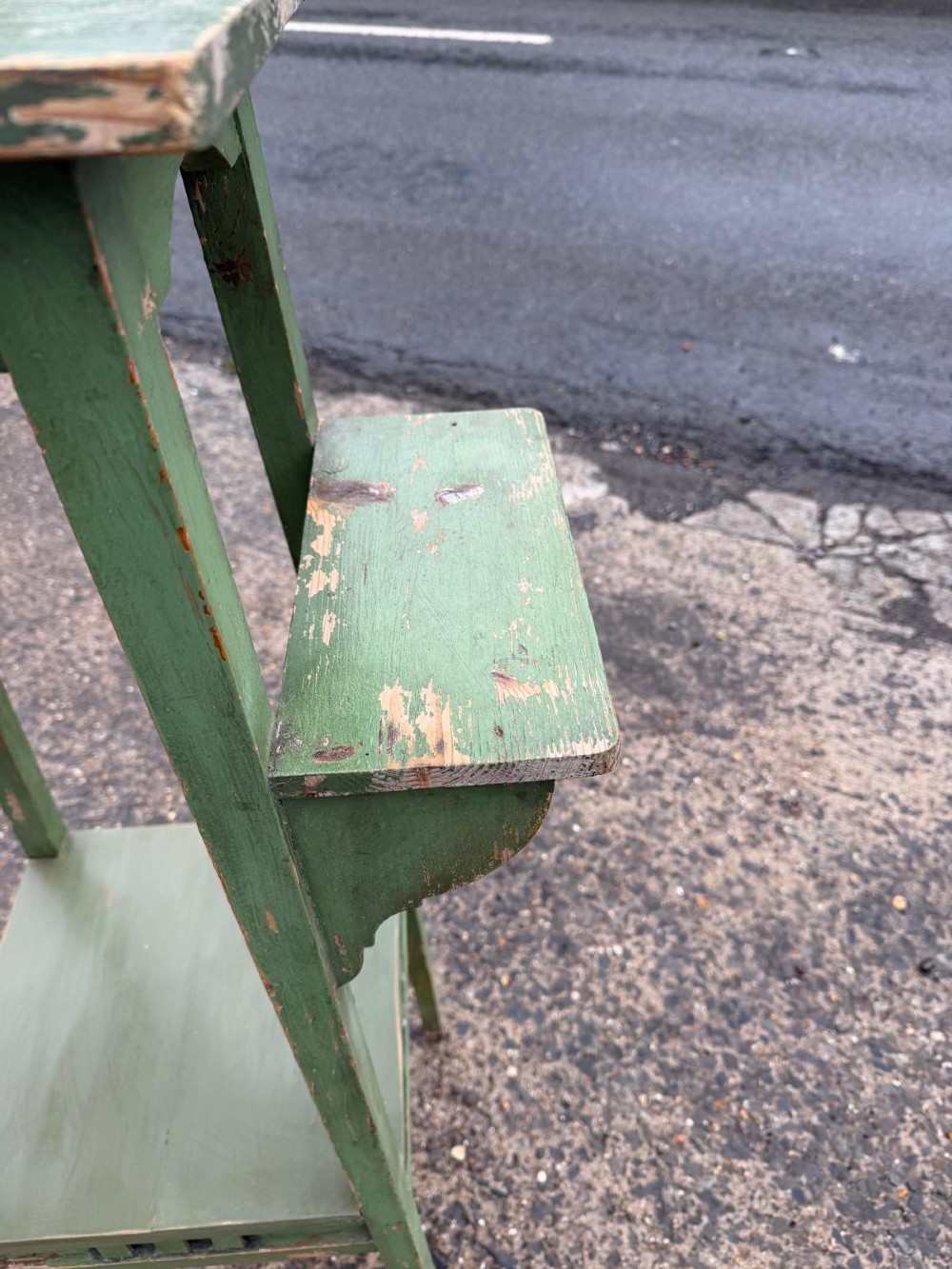 A tall, slender green painted timber plant stand circa 1900, featuring four tiered platforms and arched support brackets. View IV