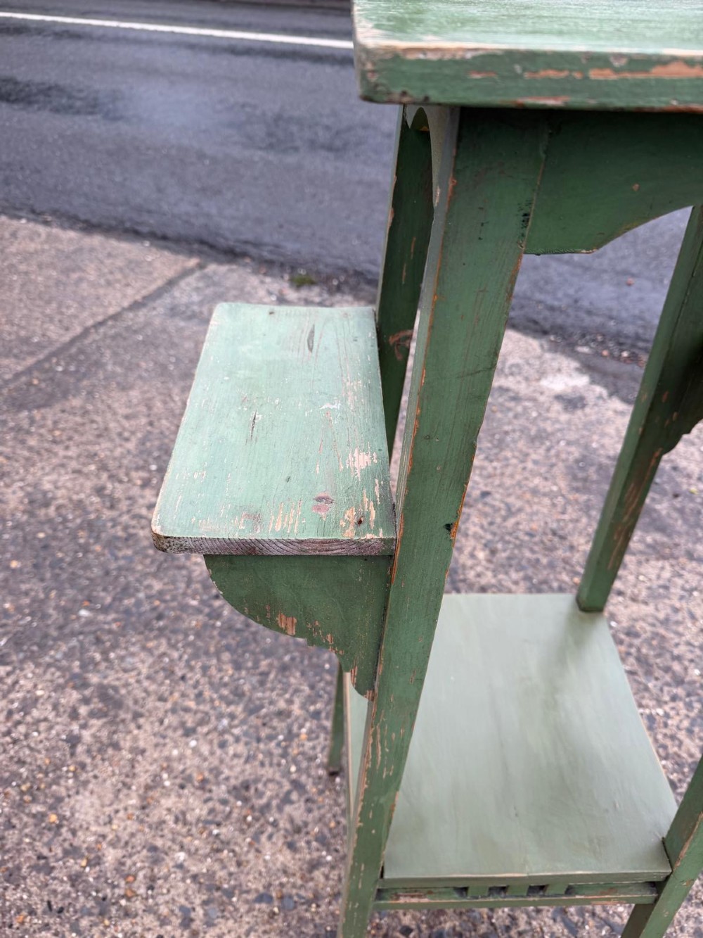 A tall, slender green painted timber plant stand circa 1900, featuring four tiered platforms and arched support brackets. View VI