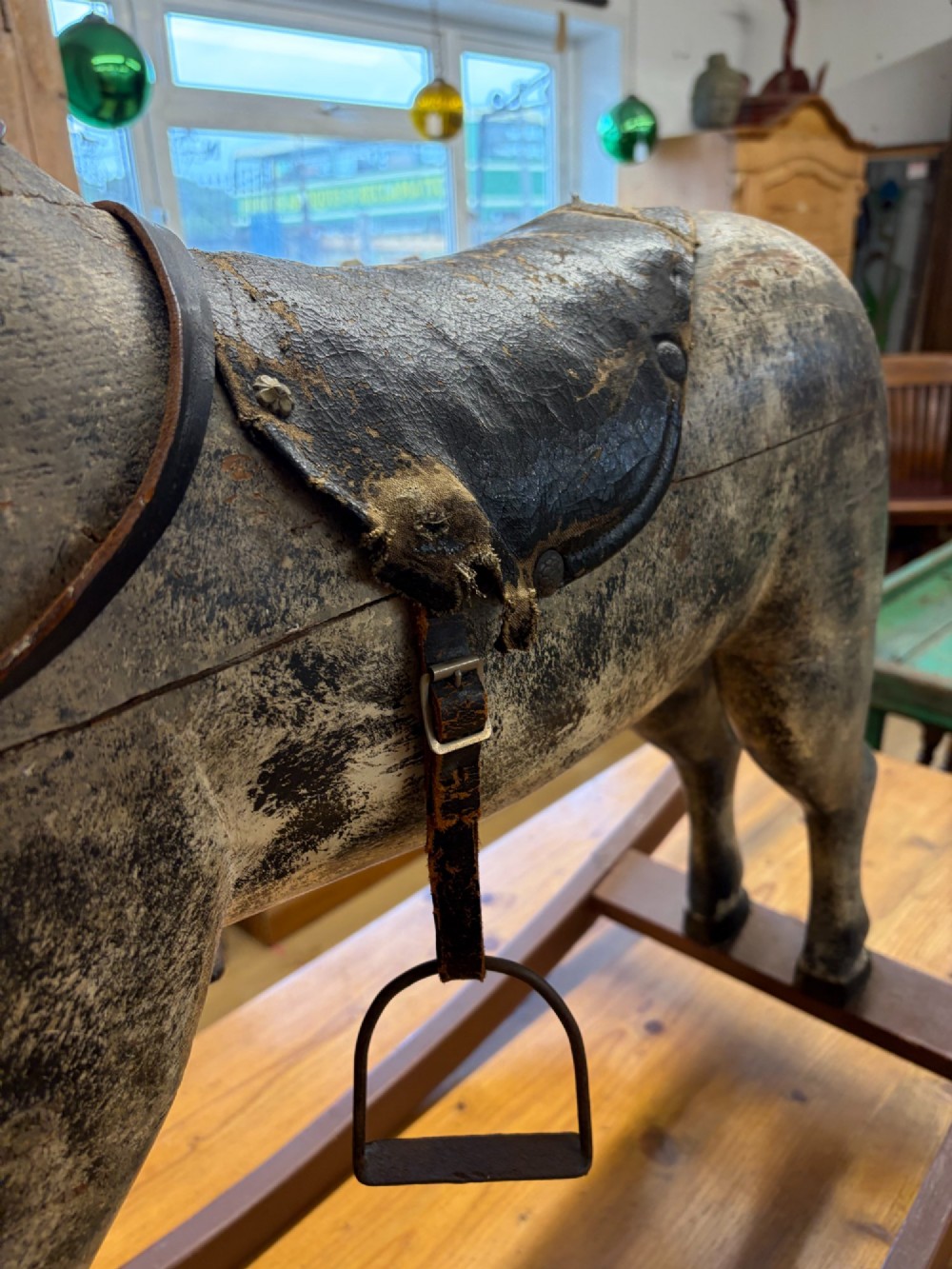 A 19th-century carved wooden primitive rocking horse with weathered paint, leather tack, and dark reddish-brown bow rockers. View VIII