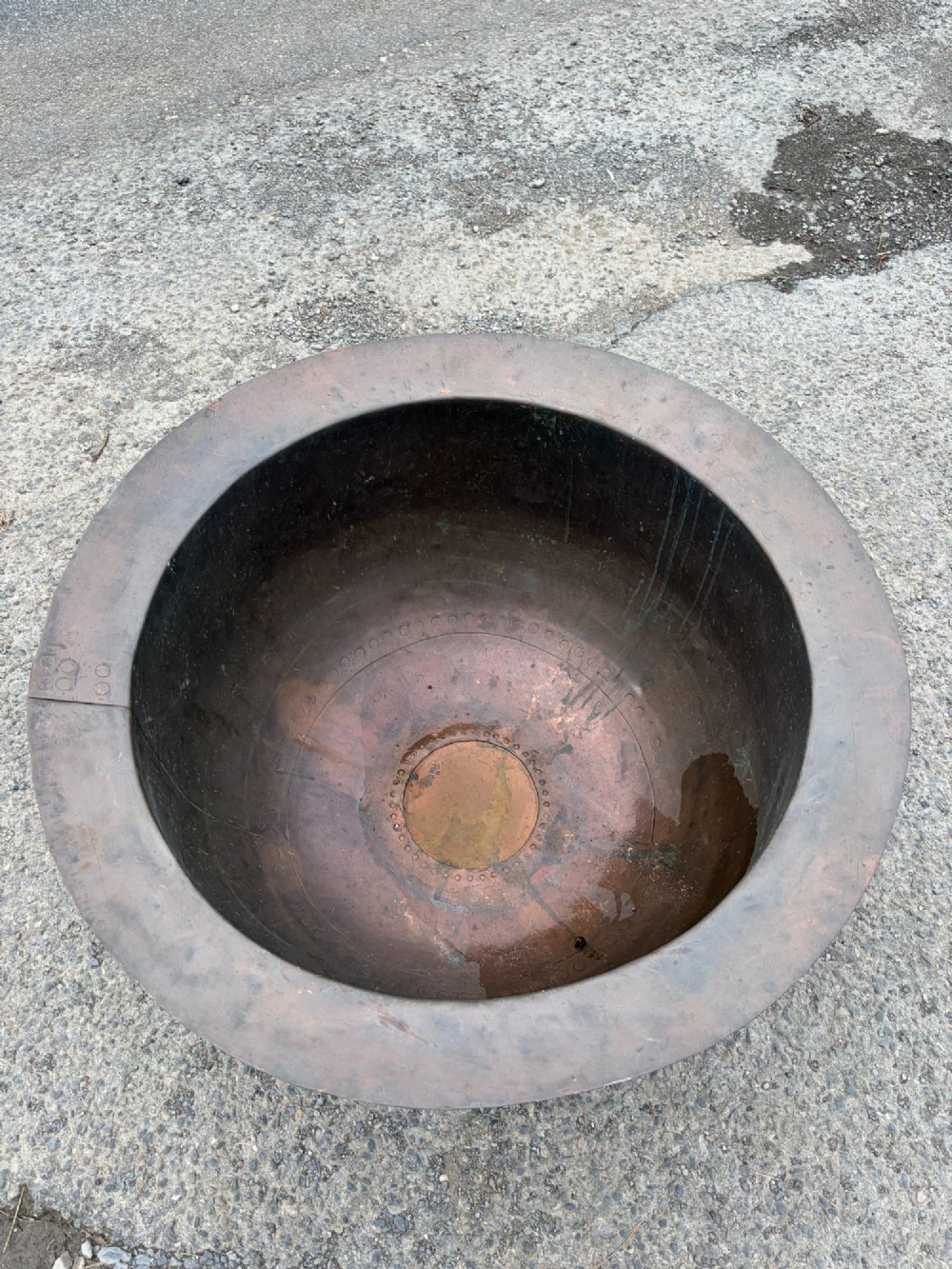A large 19th-century copper pot featuring a wide flared rim, deep rounded vessel, and dark oxidized copper patina with subtle verdigris details. View V