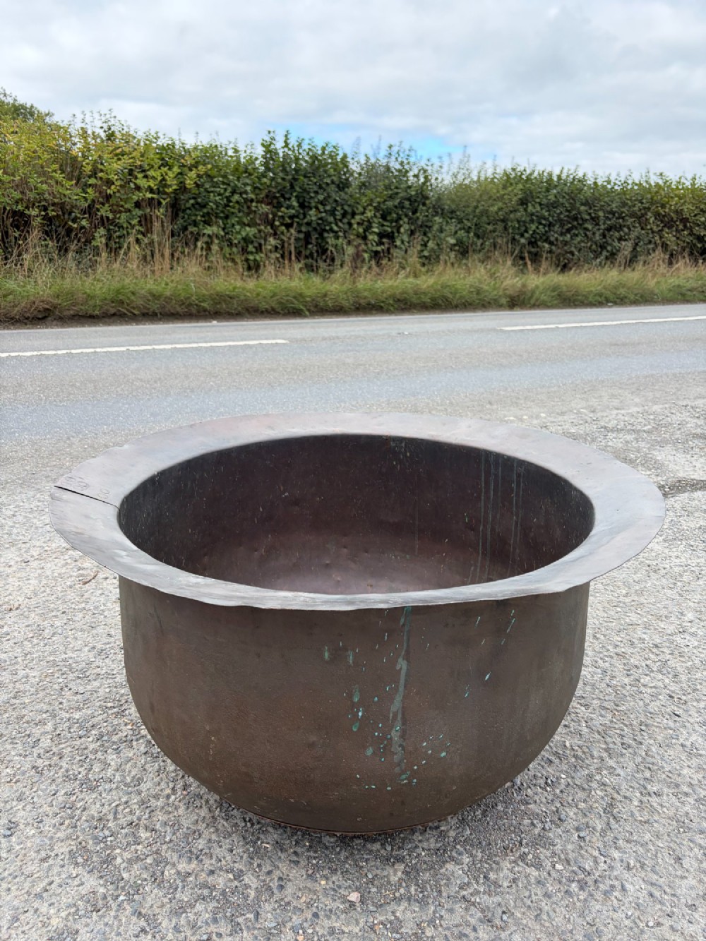 A large 19th-century copper pot featuring a wide flared rim, deep rounded vessel, and dark oxidized copper patina with subtle verdigris details. View VII