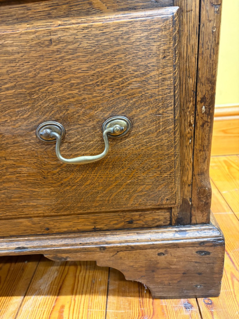 An antique George III oak housekeepers cupboard with arched fielded panels on the top doors above a base of drawers with brass handles. View XIII