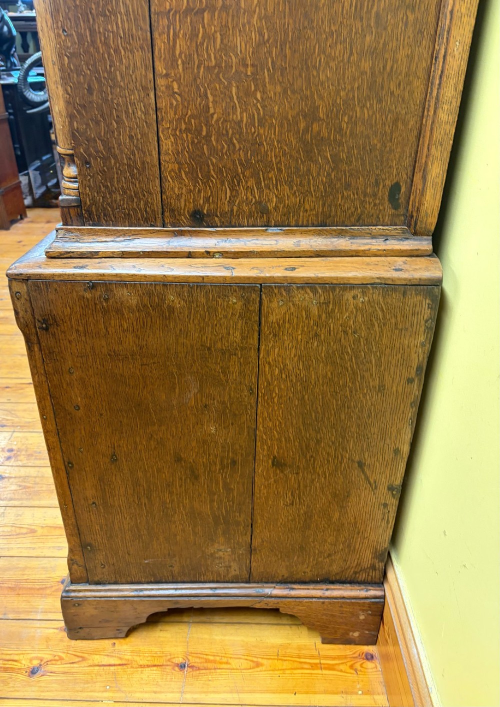 An antique George III oak housekeepers cupboard with arched fielded panels on the top doors above a base of drawers with brass handles. View XIV