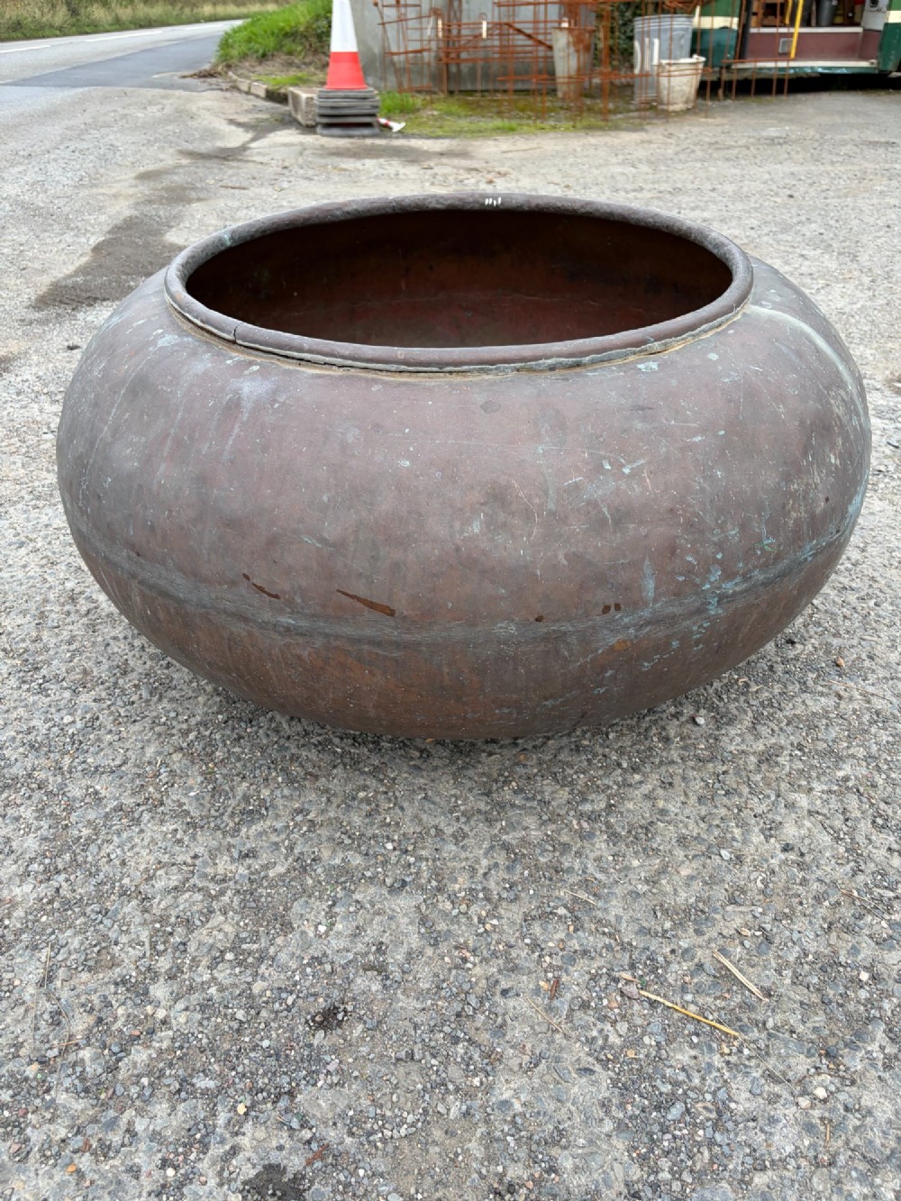A large bulbous 19th century copper pot featuring a rolled rim, a horizontal seam line, and natural verdigris oxidisation across its surface. View IV