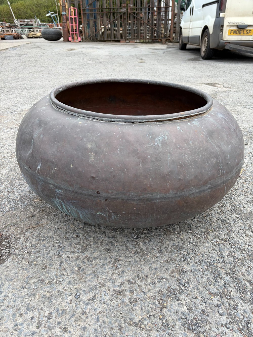 A large bulbous 19th century copper pot featuring a rolled rim, a horizontal seam line, and natural verdigris oxidisation across its surface. View V