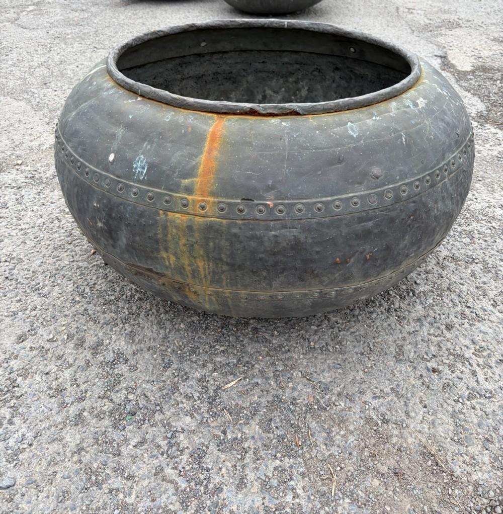 A large bulbous nineteenth-century copper vessel featuring a dark aged patina, riveted band detail, and wide circular opening. View II