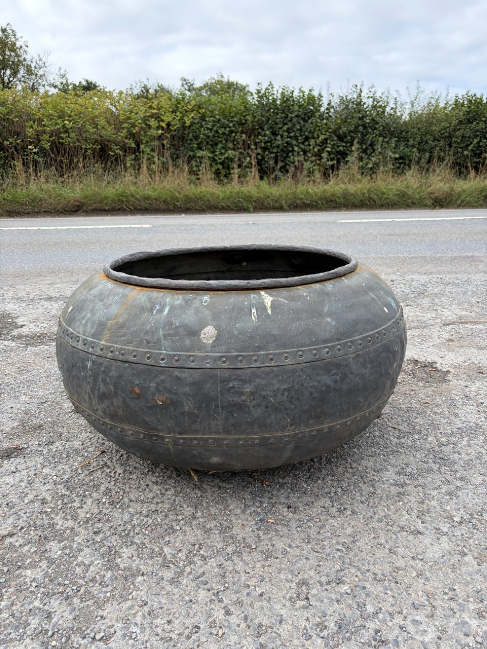 A large bulbous nineteenth-century copper vessel featuring a dark aged patina, riveted band detail, and wide circular opening. View IV