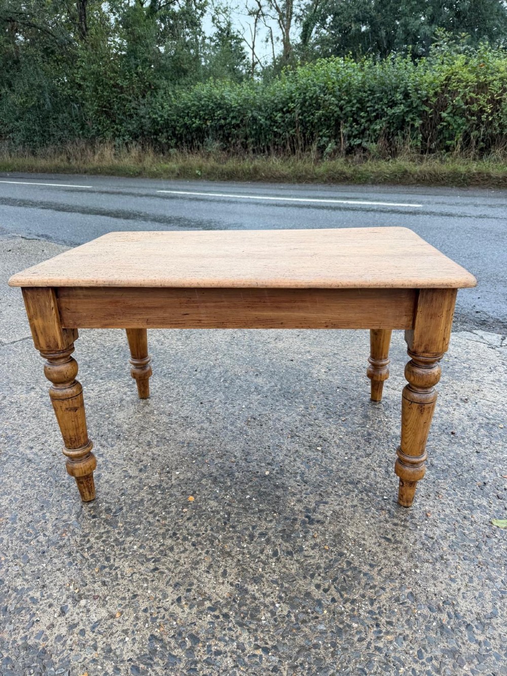 A Victorian pine table with a rectangular top, single frieze drawer, and four turned legs.