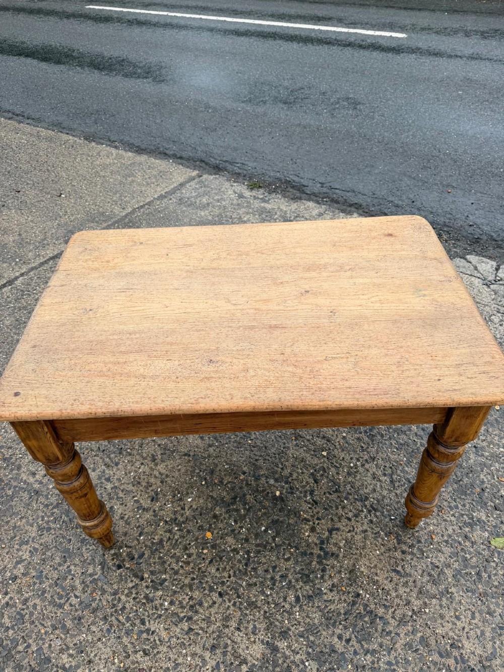 A Victorian pine table with a rectangular top, single frieze drawer, and four turned legs. View IV