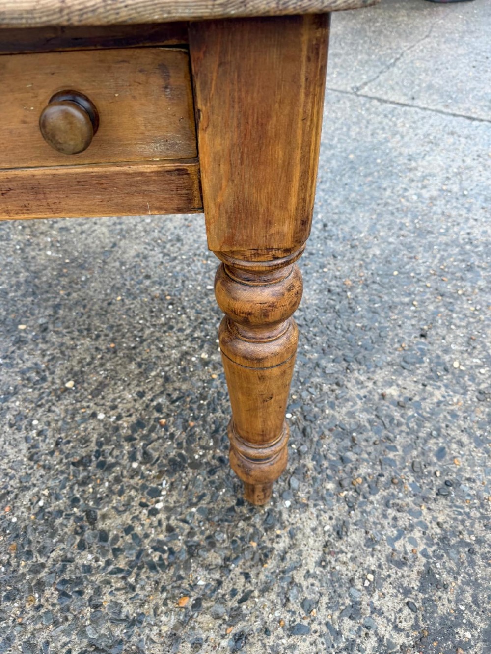 A Victorian pine table with a rectangular top, single frieze drawer, and four turned legs. View V