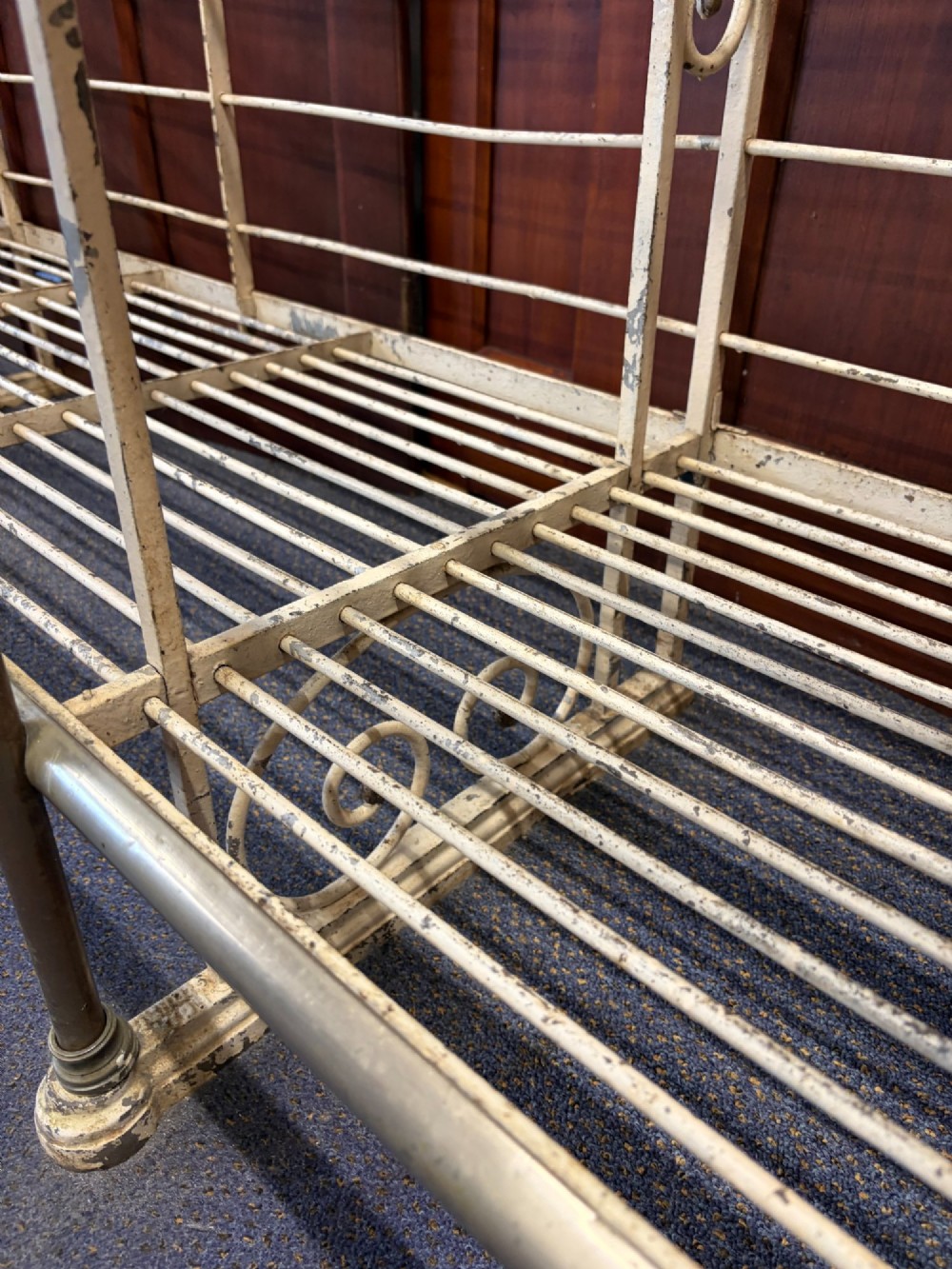 A large, multi-tiered French wrought iron bakers rack painted cream, decorated with scrollwork cresting and brass decorative elements. View II