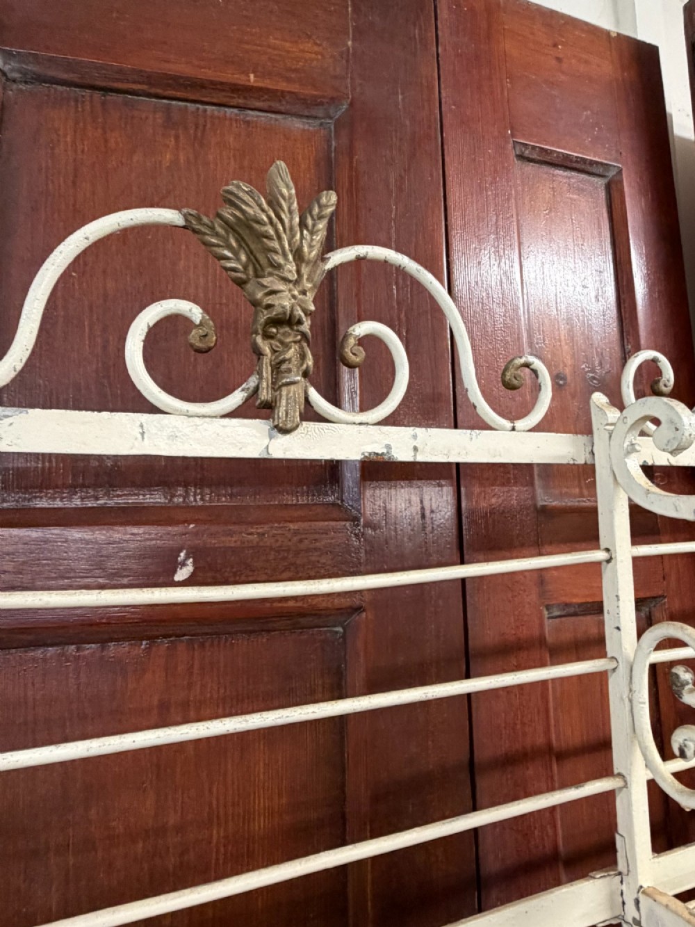 A large, multi-tiered French wrought iron bakers rack painted cream, decorated with scrollwork cresting and brass decorative elements. View III