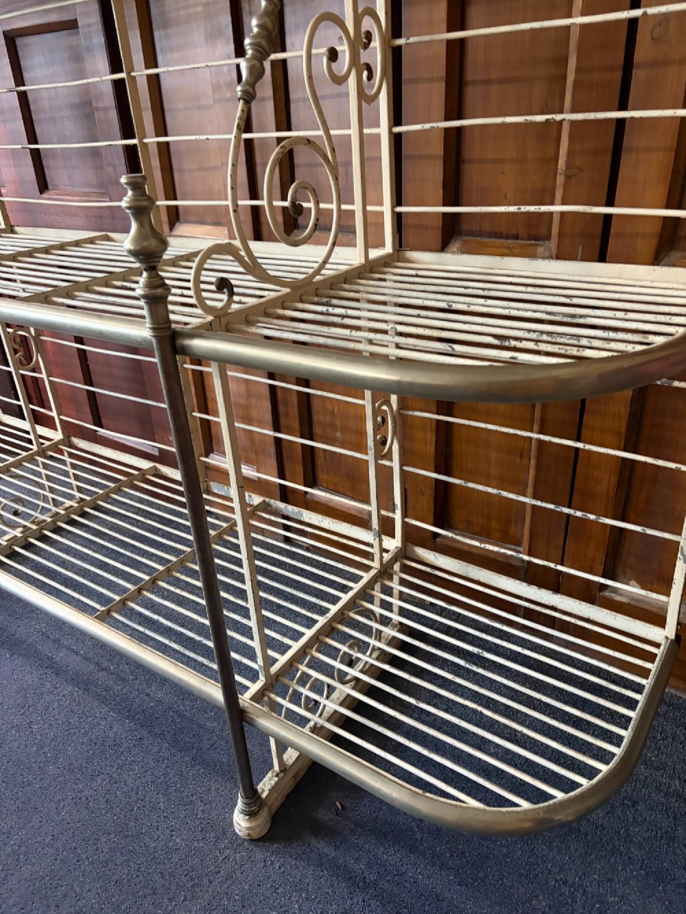 A large, multi-tiered French wrought iron bakers rack painted cream, decorated with scrollwork cresting and brass decorative elements. View VI