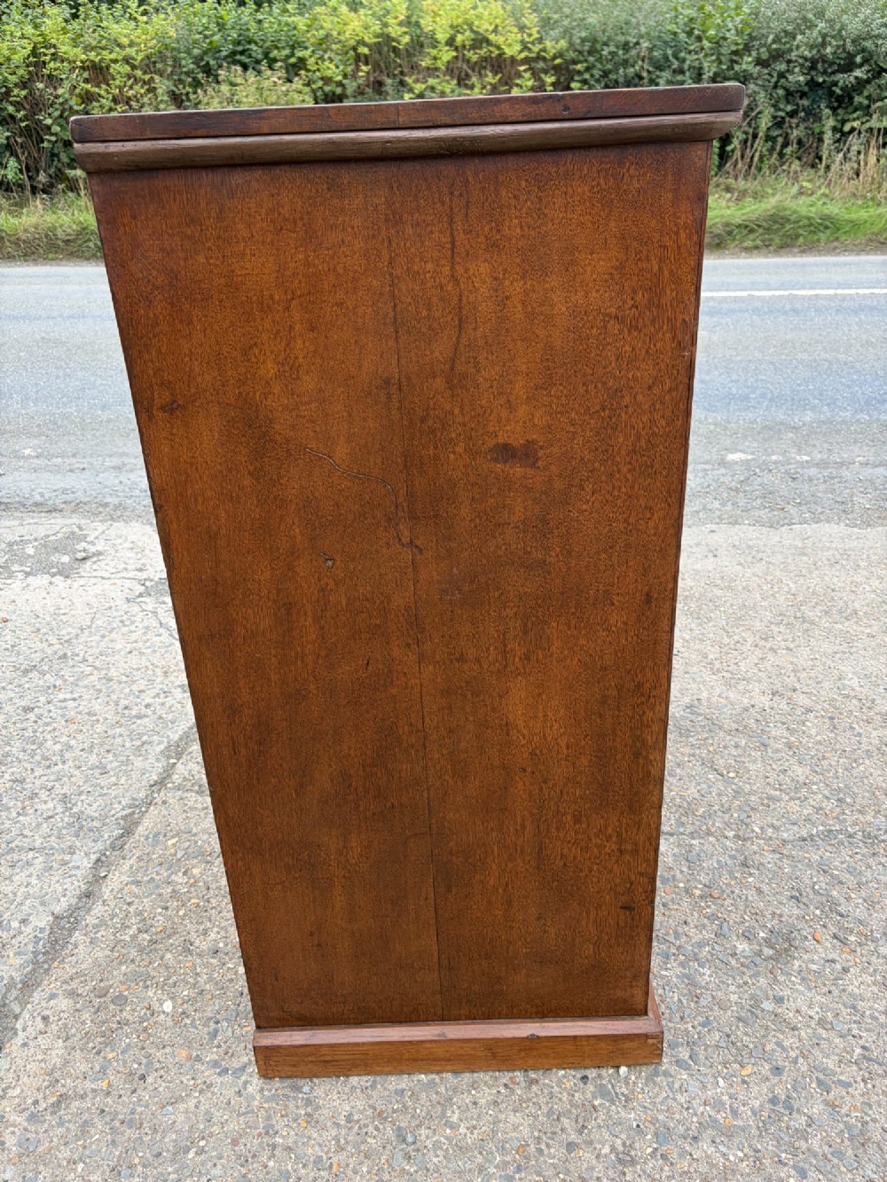 A Victorian warm brown oak chest of drawers featuring two short drawers above four full-width long drawers with turned wooden handles and keyholes. View II