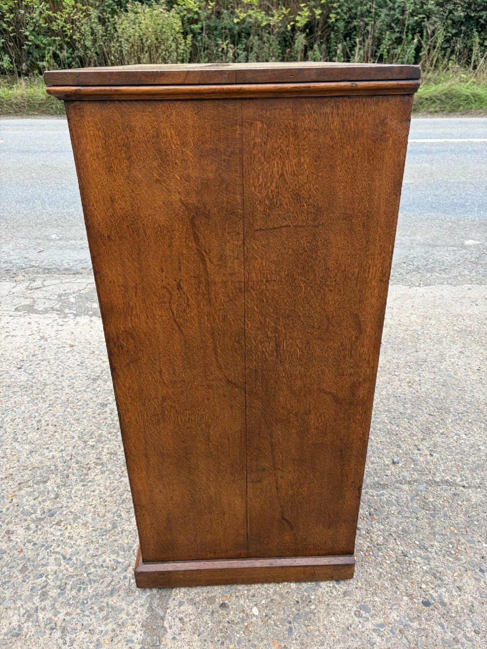 A Victorian warm brown oak chest of drawers featuring two short drawers above four full-width long drawers with turned wooden handles and keyholes. View VI