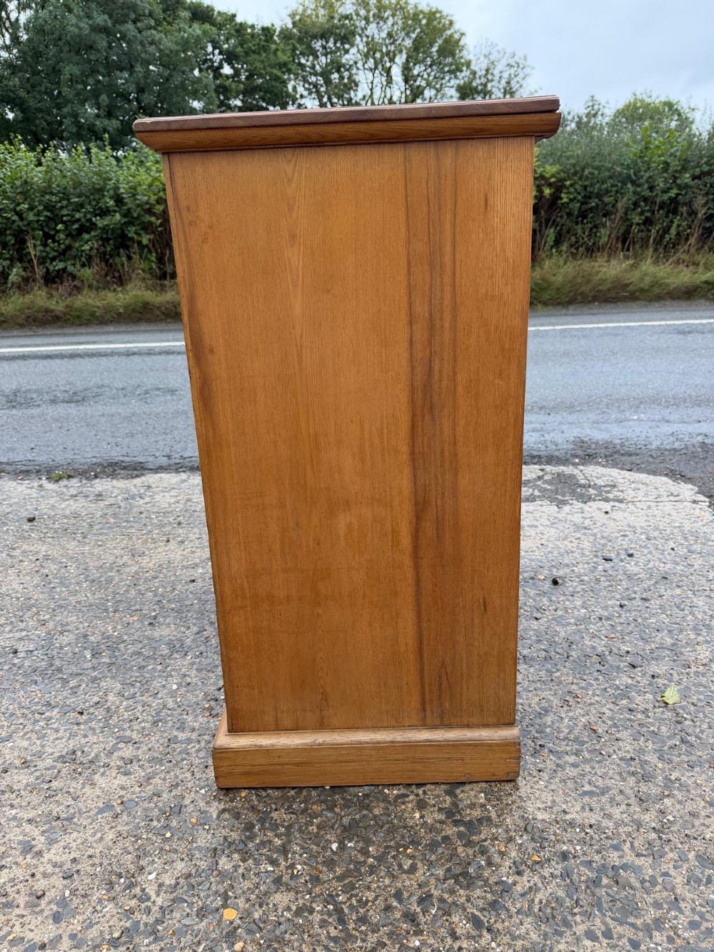 A solid oak chest of drawers featuring a two over three drawer layout with fluted side pilasters and brass acorn drop handles set on a solid base. View II