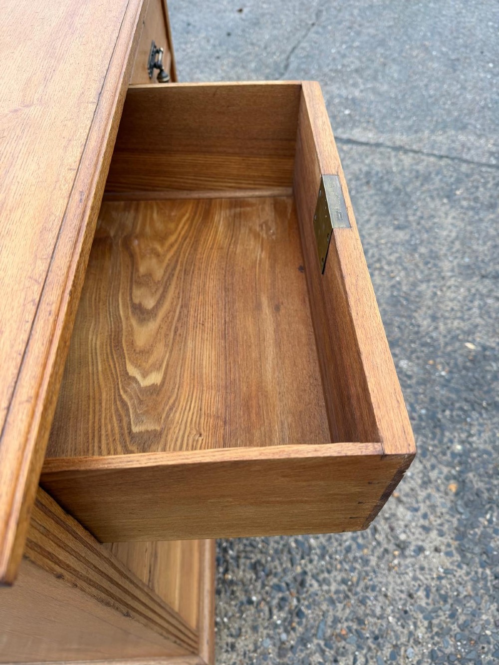 A solid oak chest of drawers featuring a two over three drawer layout with fluted side pilasters and brass acorn drop handles set on a solid base. View III