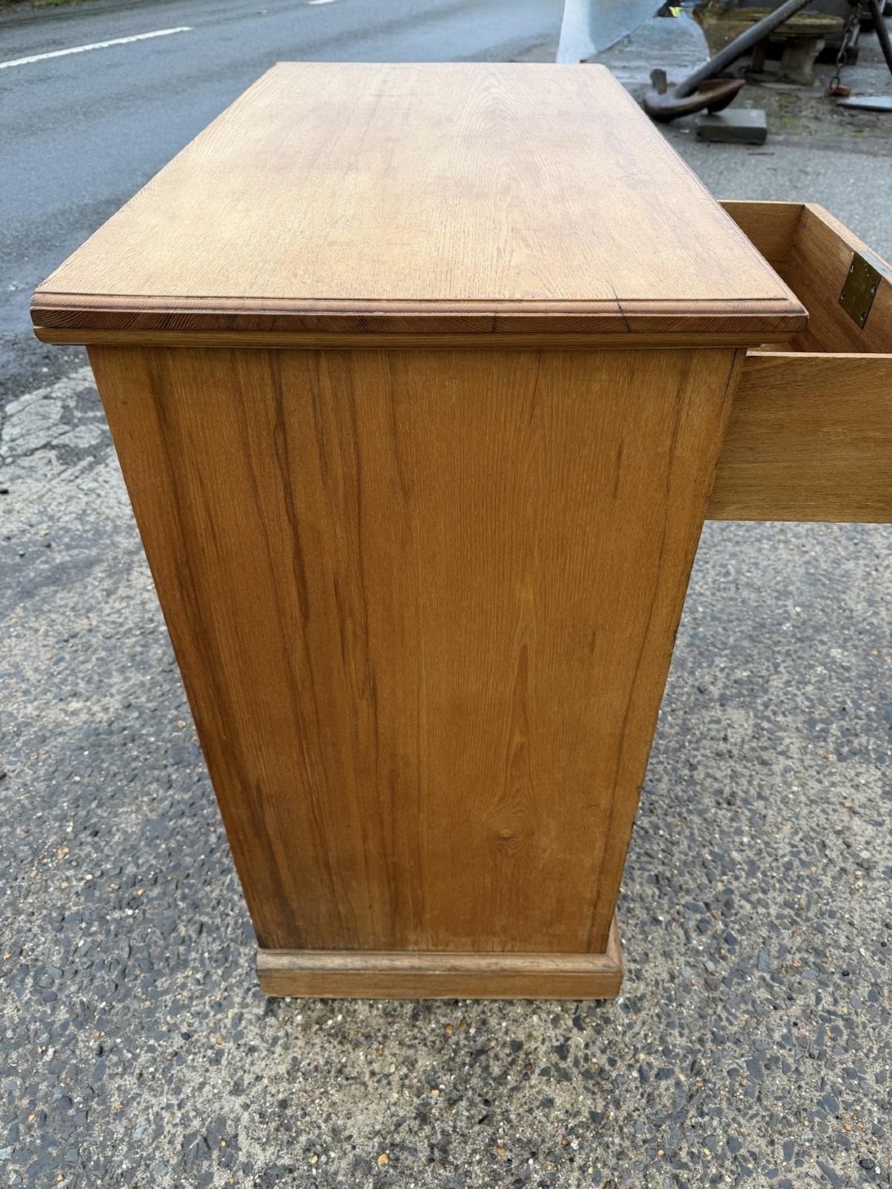 A solid oak chest of drawers featuring a two over three drawer layout with fluted side pilasters and brass acorn drop handles set on a solid base. View IV
