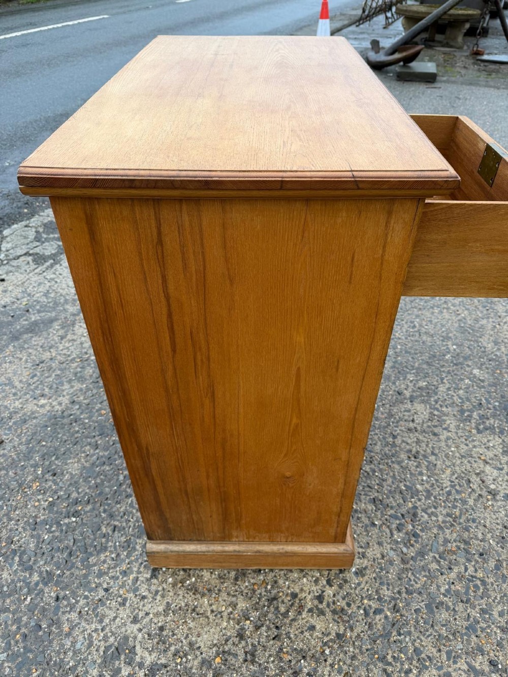 A solid oak chest of drawers featuring a two over three drawer layout with fluted side pilasters and brass acorn drop handles set on a solid base. View VIII