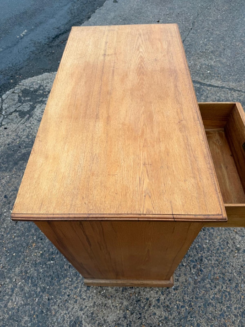A solid oak chest of drawers featuring a two over three drawer layout with fluted side pilasters and brass acorn drop handles set on a solid base. View IX