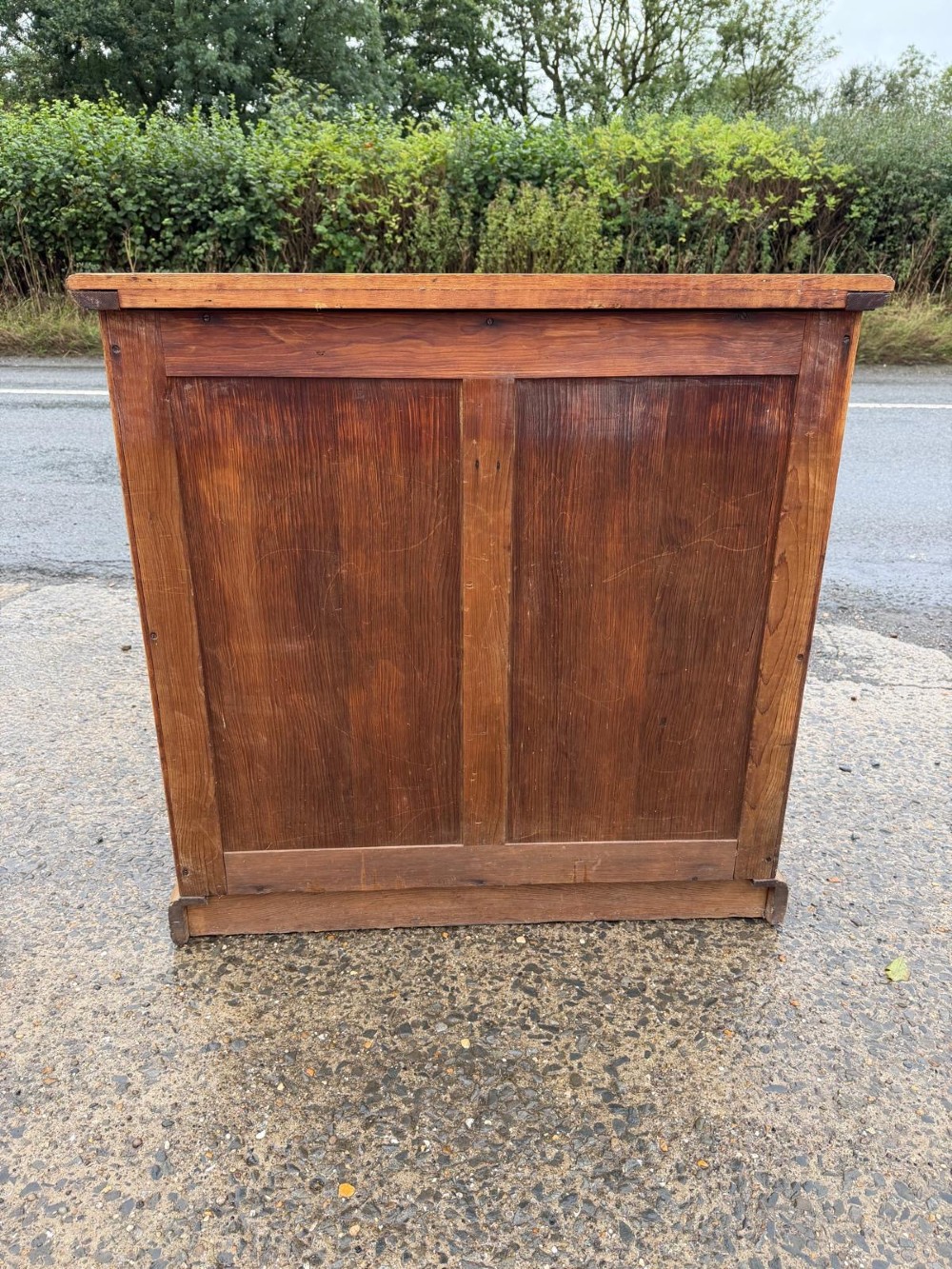 A solid oak chest of drawers featuring a two over three drawer layout with fluted side pilasters and brass acorn drop handles set on a solid base. View X