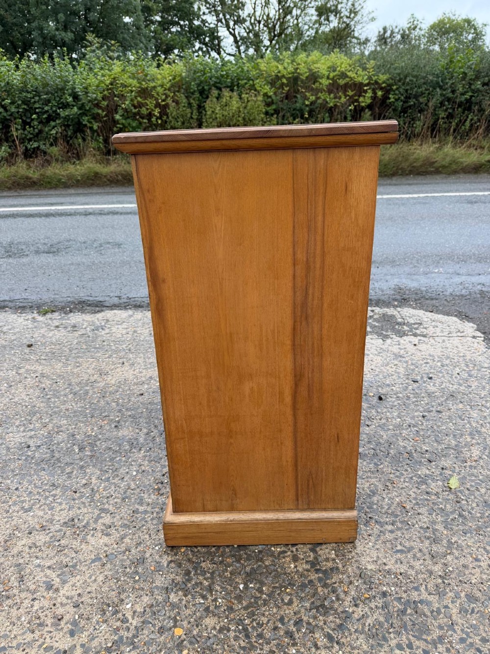 A solid oak chest of drawers featuring a two over three drawer layout with fluted side pilasters and brass acorn drop handles set on a solid base. View XI