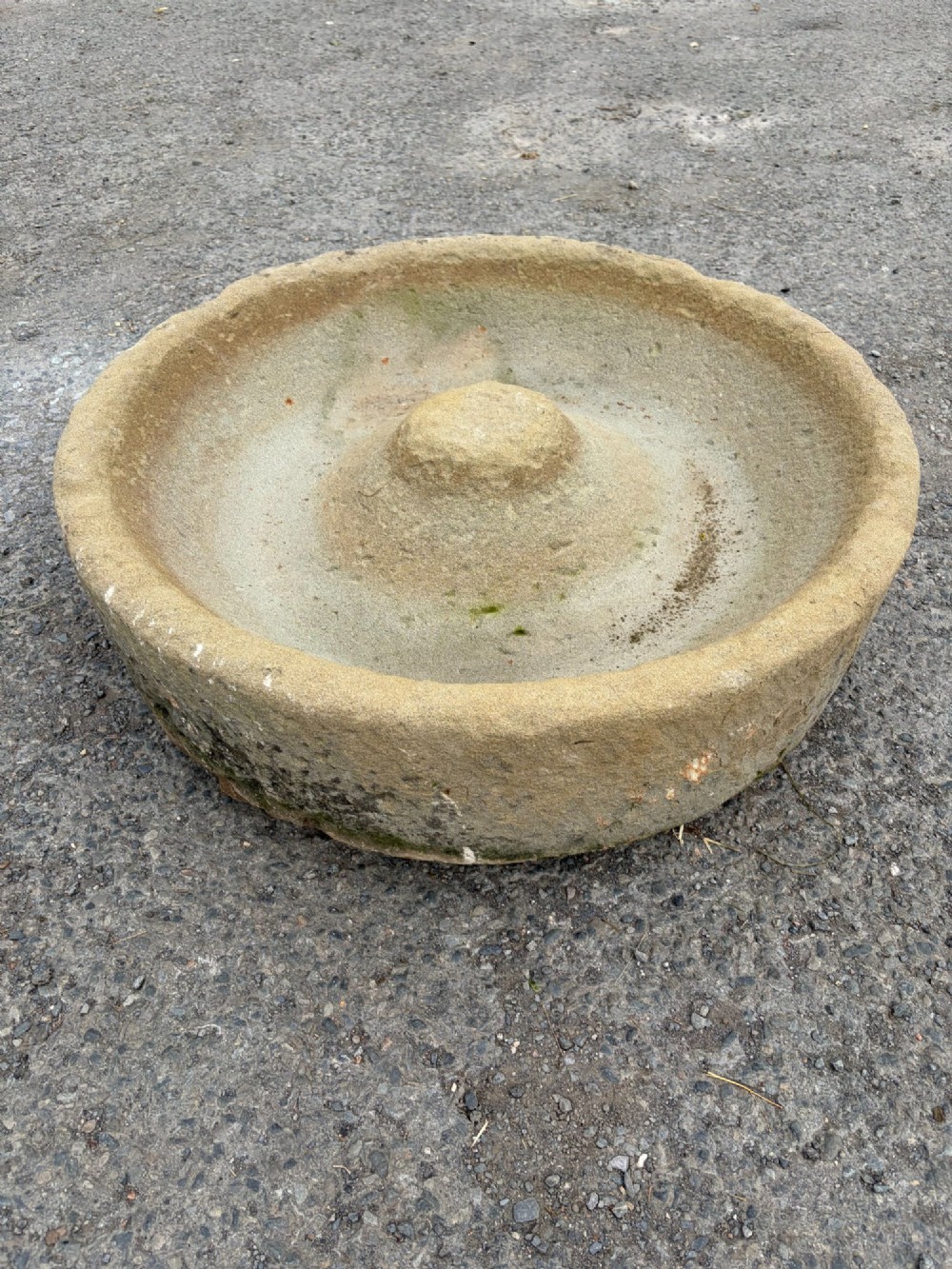 A circular hand-carved antique sandstone pig trough featuring a raised central cone and weathered exterior surface. View II