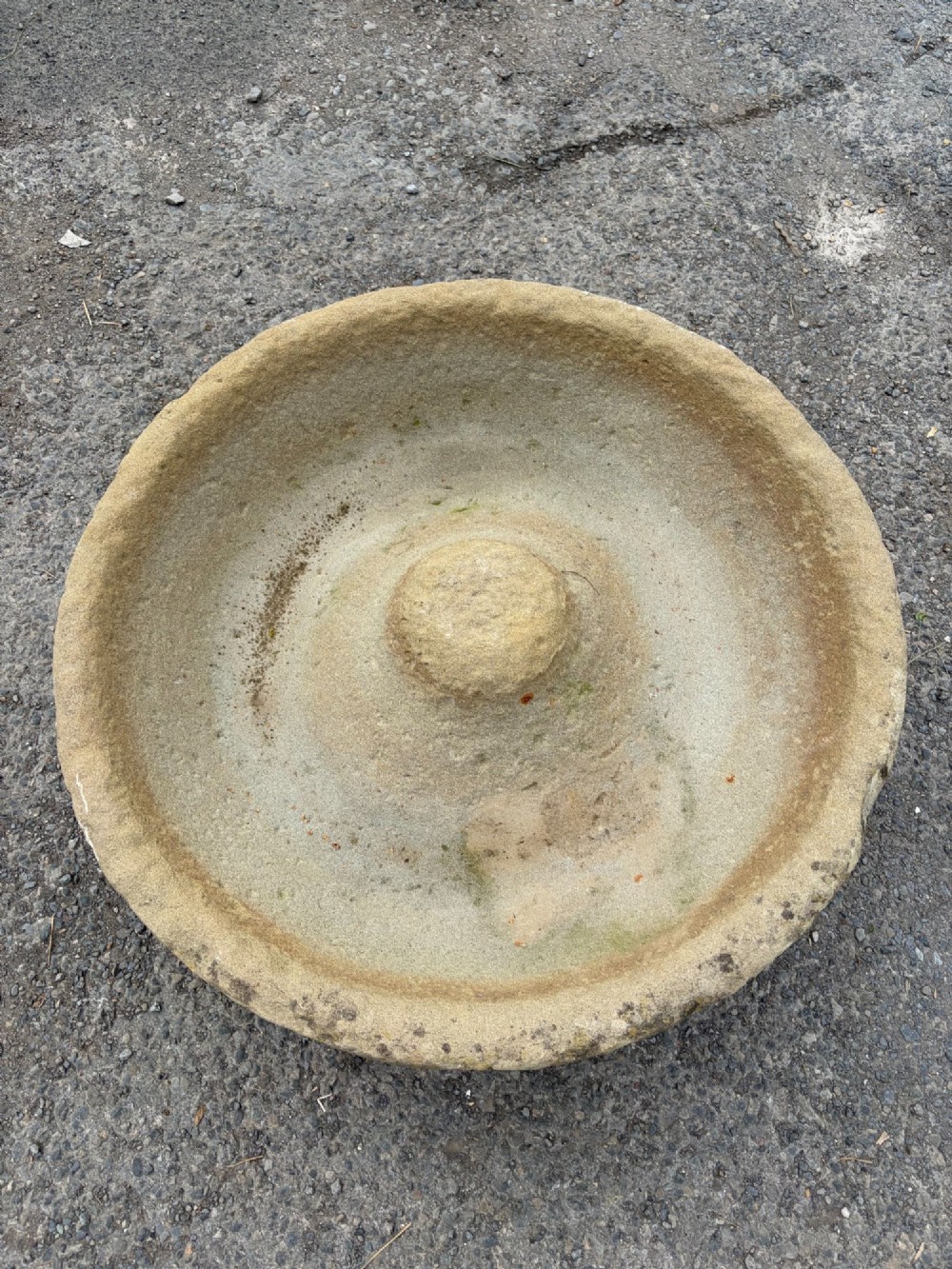 A circular hand-carved antique sandstone pig trough featuring a raised central cone and weathered exterior surface. View VI