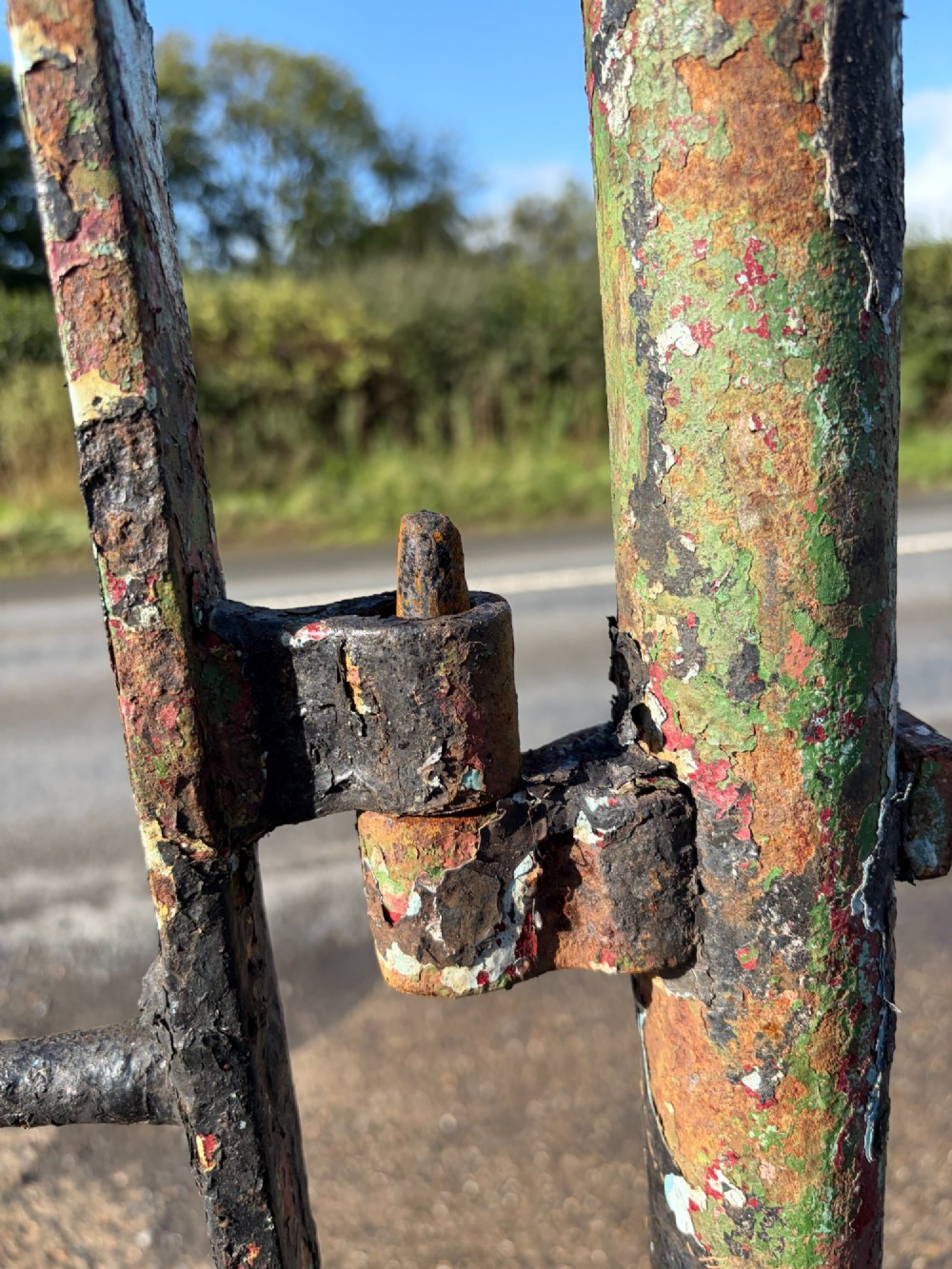 An early 19th-century wrought iron pedestrian field gate with supporting posts, horizontal bars, diagonal bracing, and a weathered paint finish. View III