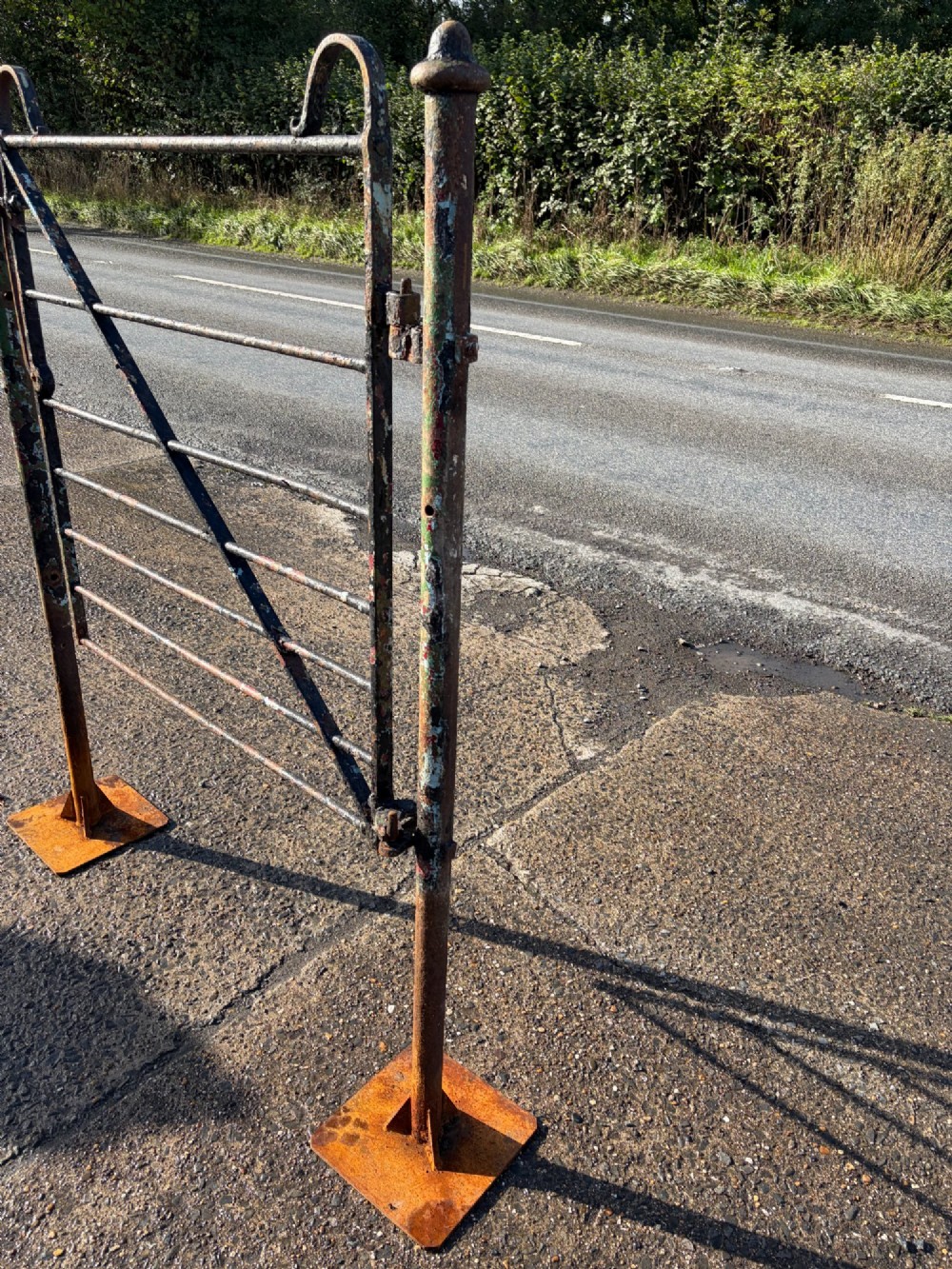 An early 19th-century wrought iron pedestrian field gate with supporting posts, horizontal bars, diagonal bracing, and a weathered paint finish. View IV
