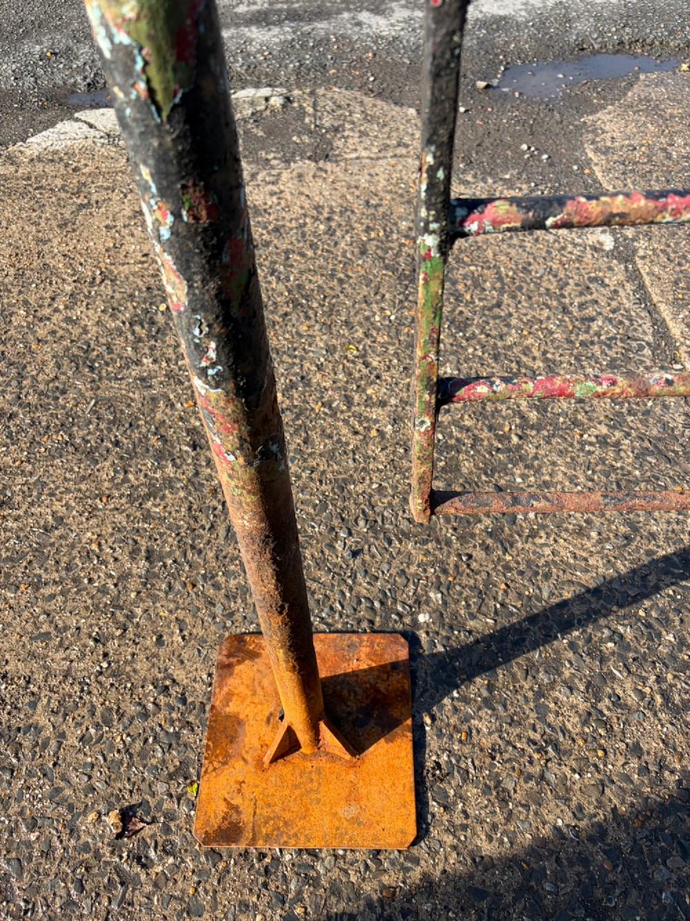 An early 19th-century wrought iron pedestrian field gate with supporting posts, horizontal bars, diagonal bracing, and a weathered paint finish. View VII