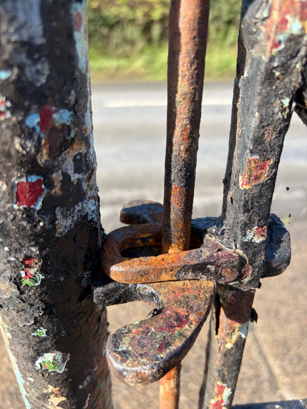 An early 19th-century wrought iron pedestrian field gate with supporting posts, horizontal bars, diagonal bracing, and a weathered paint finish. View XII