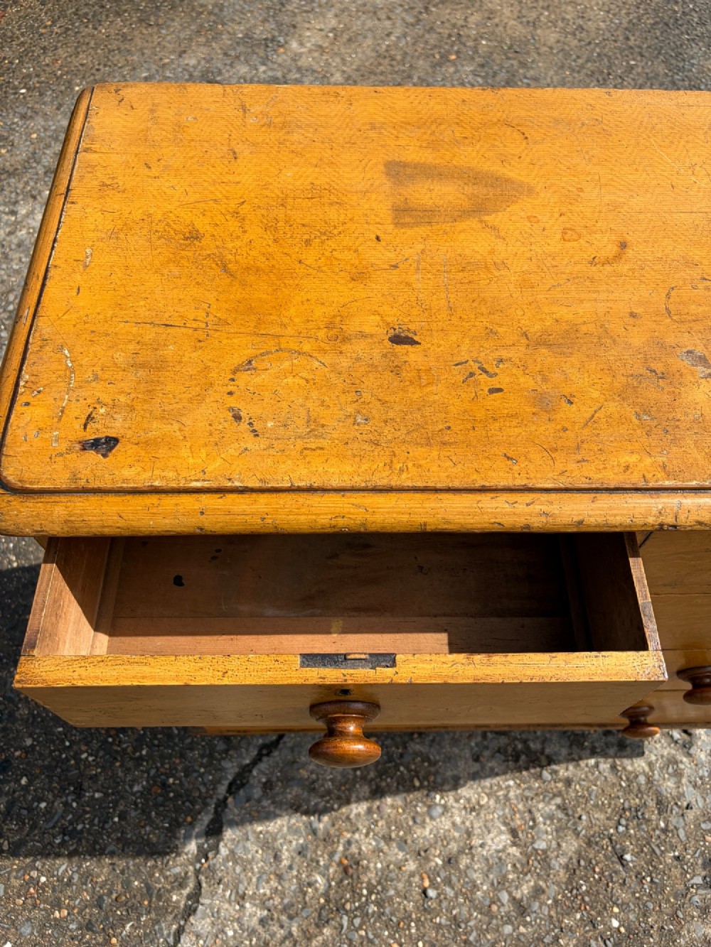 A Victorian pine chest of drawers featuring a faux-grained finish, two short drawers over three long drawers, turned wooden knobs, and turned feet. View V