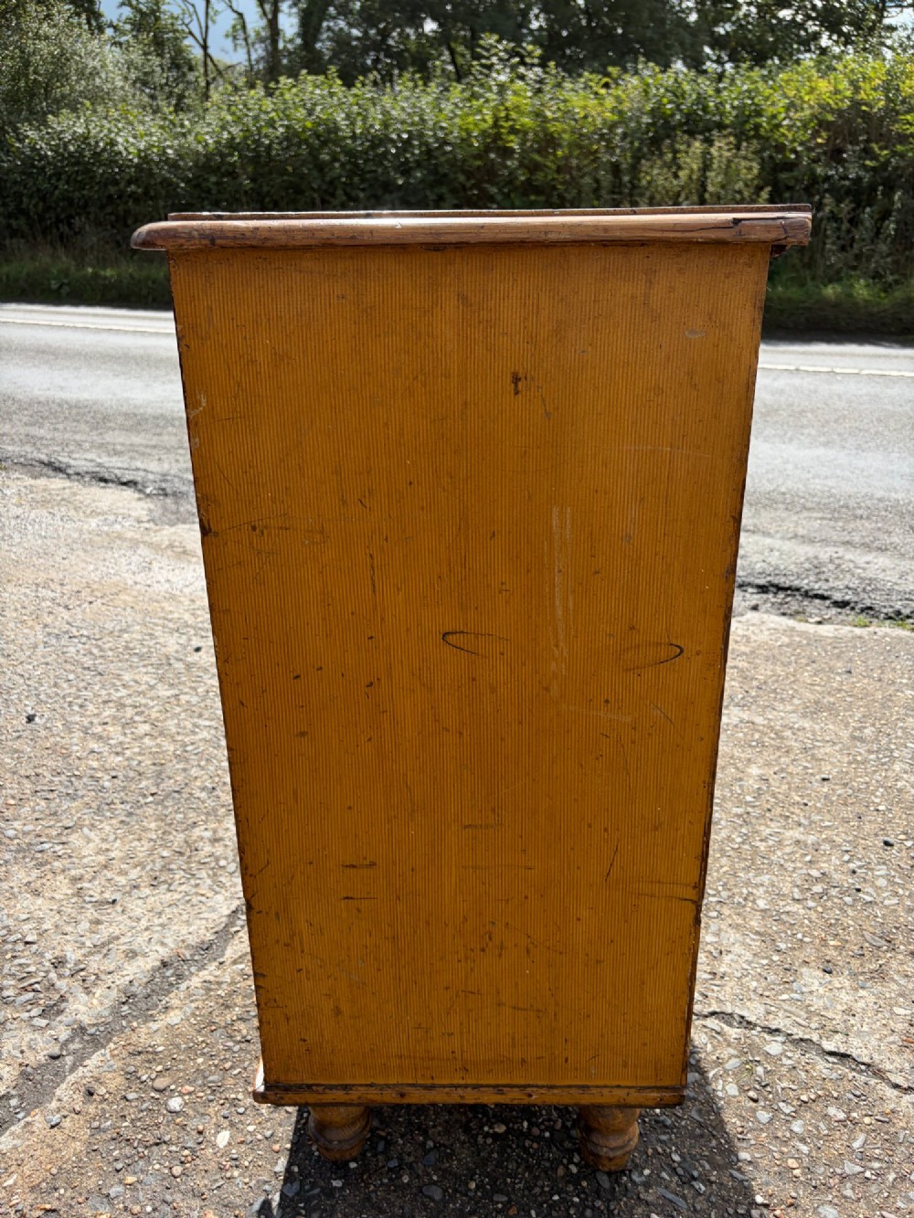 A Victorian pine chest of drawers featuring a faux-grained finish, two short drawers over three long drawers, turned wooden knobs, and turned feet. View VIII