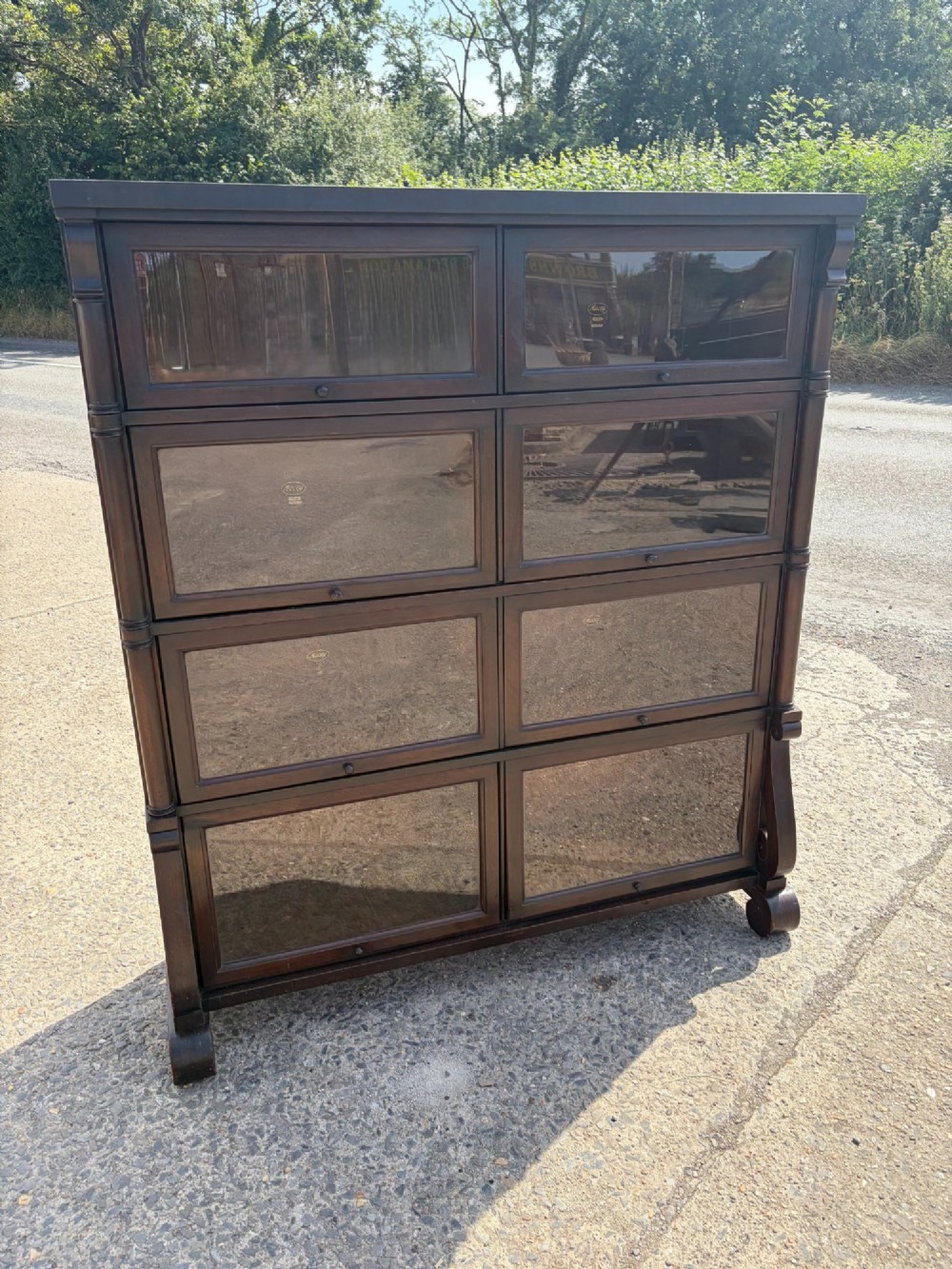 A 1920s dark mahogany double-width sectional bookcase featuring four stacked tiers fitted with glazed up-and-over doors. View II