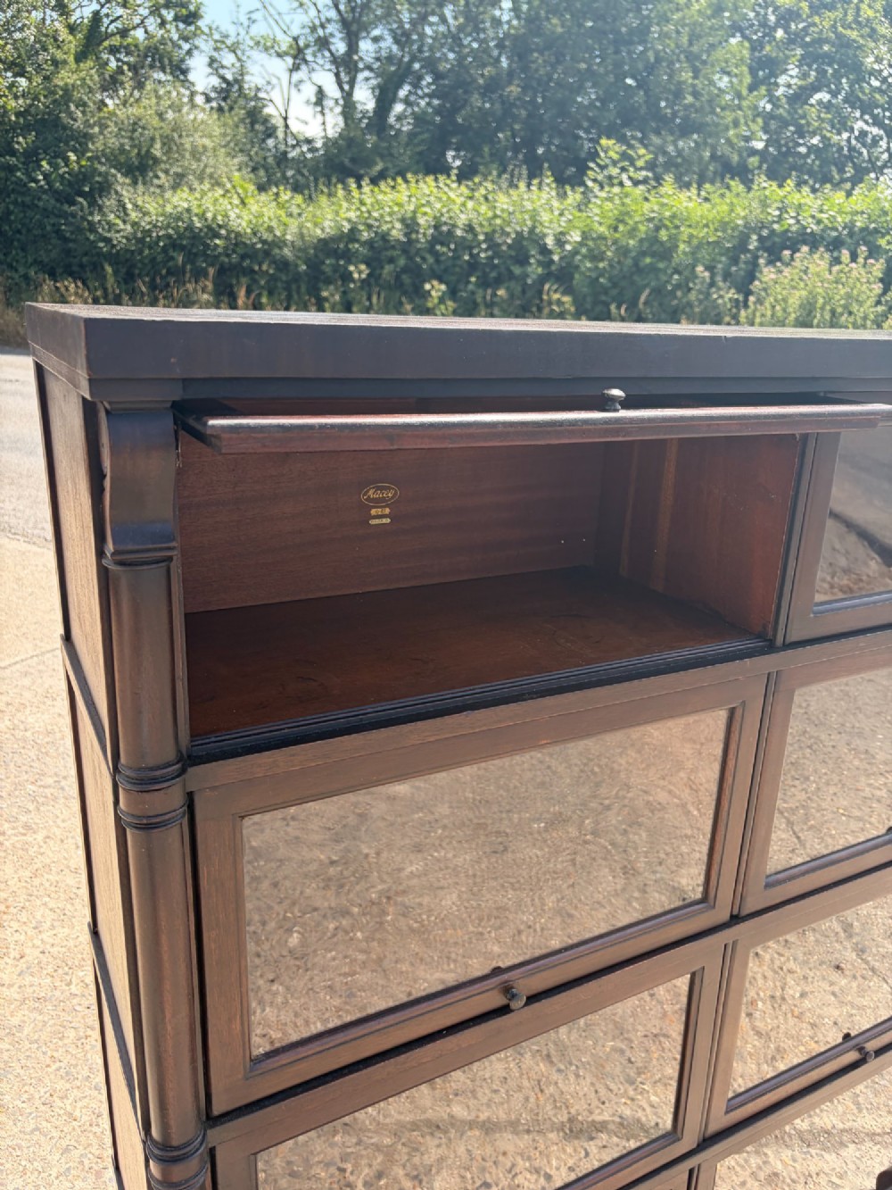 A 1920s dark mahogany double-width sectional bookcase featuring four stacked tiers fitted with glazed up-and-over doors. View IV
