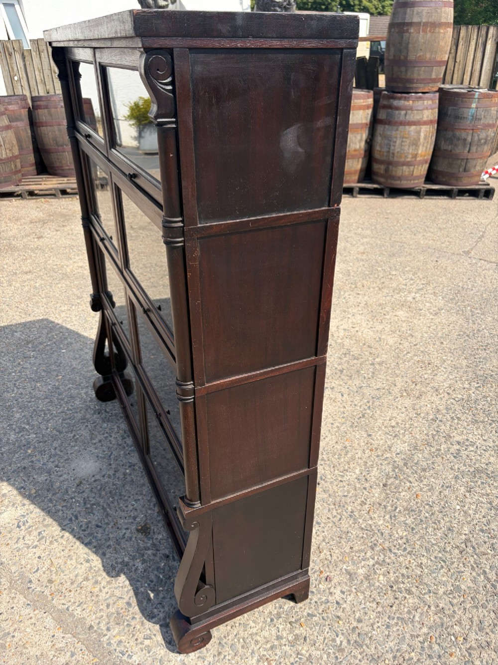 A 1920s dark mahogany double-width sectional bookcase featuring four stacked tiers fitted with glazed up-and-over doors. View VII