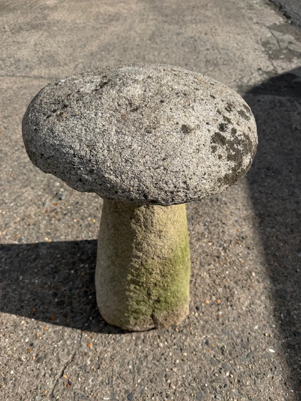 A hand-hewn grey Cornish granite staddle stone with a tapered base and rounded cap resting on a flat surface. View V