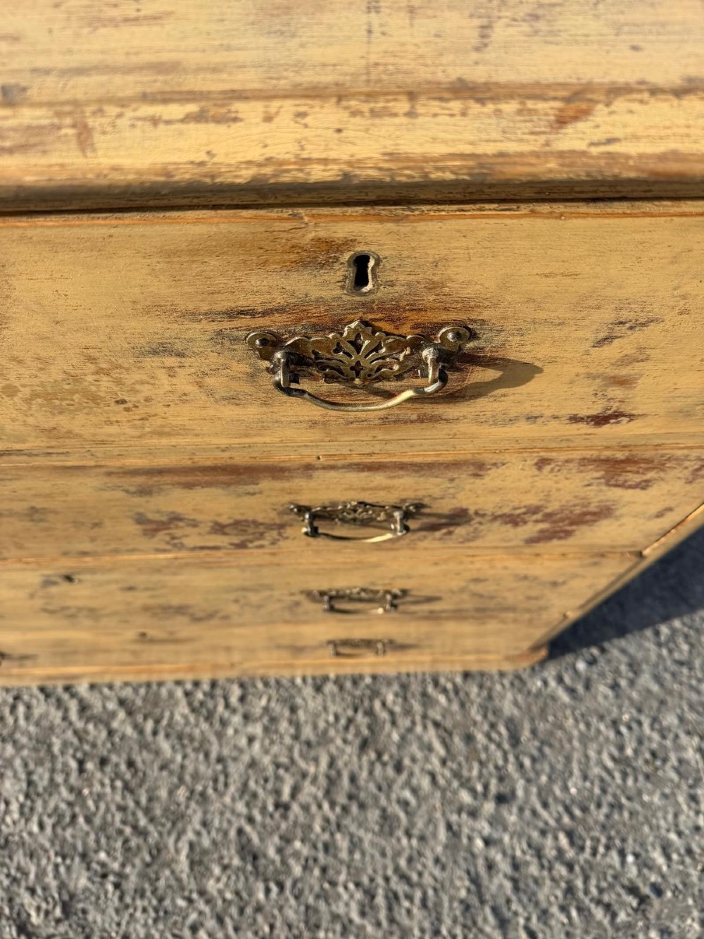 A Victorian painted pine chest of drawers in a two over three drawer layout with brass drop handles and distressed original yellow paint. View VI