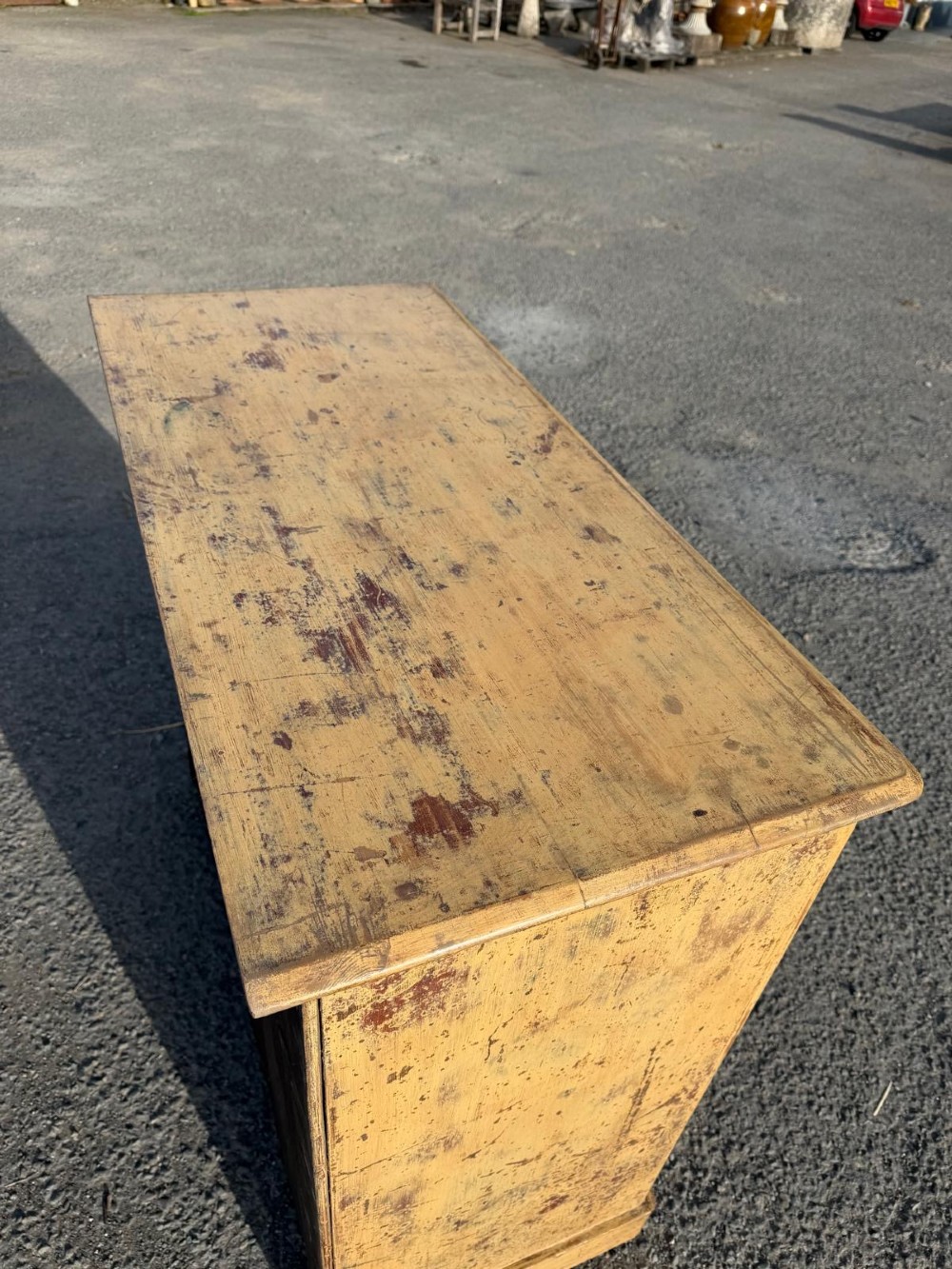 A Victorian painted pine chest of drawers in a two over three drawer layout with brass drop handles and distressed original yellow paint. View VII