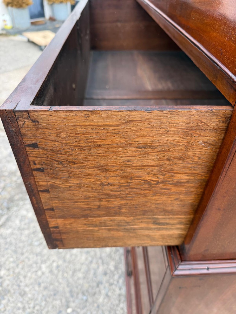 A tall Georgian mahogany chest on chest featuring eight drawers with brass swan-neck handles, resting on bracket feet. View III