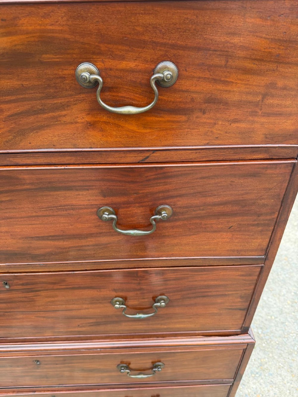A tall Georgian mahogany chest on chest featuring eight drawers with brass swan-neck handles, resting on bracket feet. View VII